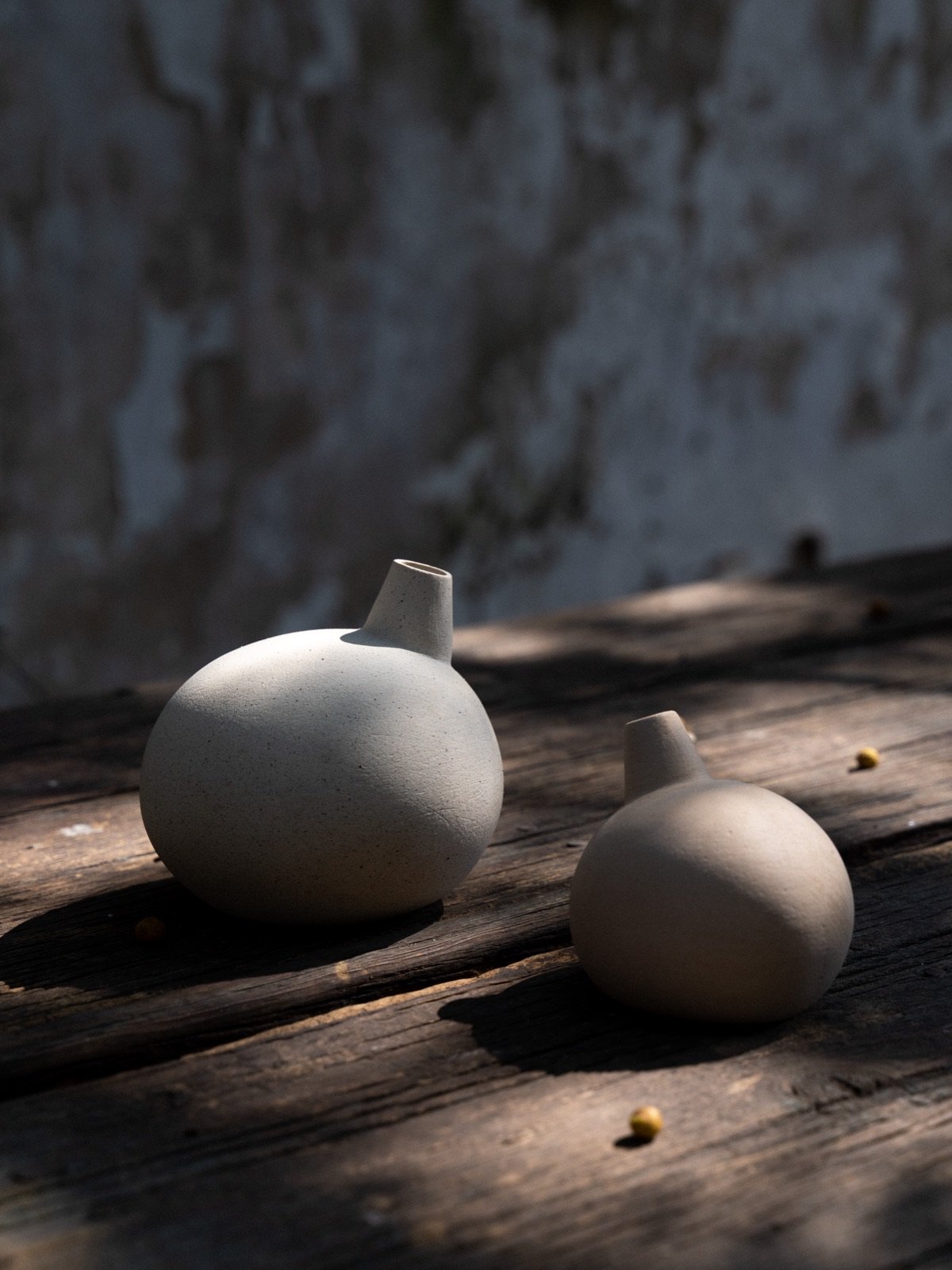 Two white vessels on a wooden table